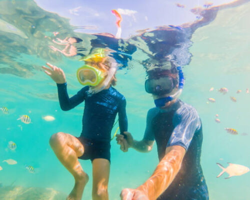 Underwater portrait of father and son snorkeling together.