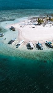 Beautiful Gili Islands beach with boats and clear blue water.