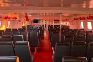 Empty fastboat interior with black seats and red flooring.