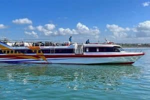 Fastboat cruising on calm waters near Lombok with blue sky and clouds.