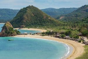 Scenic view of Kuta Beach with hills and clear blue water in Lombok.